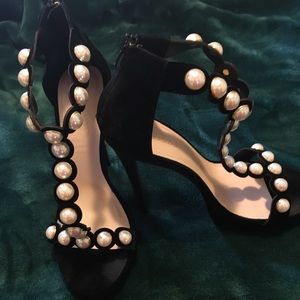 Black velvet high heeled shoe with pearl detail.